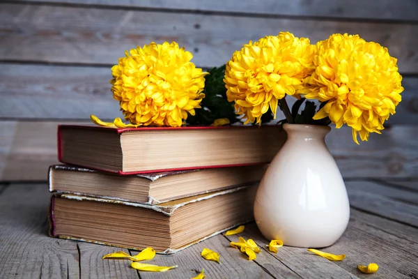 鲜花。美丽的黄色的菊花在一个古董花瓶。一杯咖啡。明亮的 Servais、 杯子和碟子。美丽的早餐。旧书上木制的背景. — 图库照片