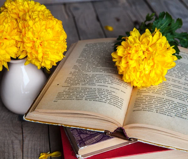 Flowers. Beautiful yellow chrysanthemum in a vintage vase. Cup of coffee. Bright Servais, cup and saucer .. Beautiful breakfast.Old books on a wooden background. — Stock Photo, Image