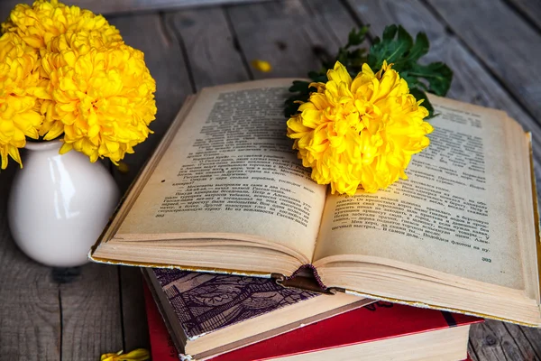 Fiori. Bellissimo crisantemo giallo in un vaso vintage. Una tazza di caffè. Servais luminoso, tazza e piattino.. Bella colazione. Vecchi libri su uno sfondo di legno . — Foto Stock