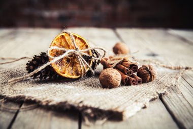 Çam kozalakları ve ahşap bir adam üzerinde fındık ile kurutulmuş portakal bağlı