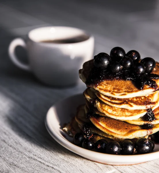 Pancakes with currant jam and a cup of tea — Stock Photo, Image
