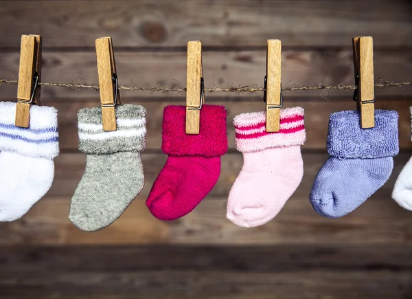 Gray sock with a clothespin on a wooden background — Stock Photo, Image