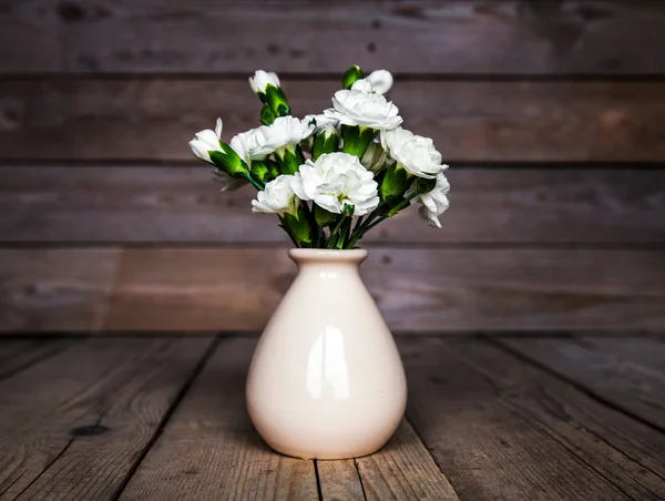 Delicato bouquet di garofani in vaso d'epoca con cuore su fondo ligneo. San Valentino — Foto Stock