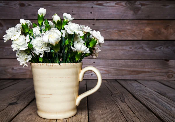 Delicado buquê de cravos em vaso vintage com coração em fundo de madeira. Dia dos Namorados — Fotografia de Stock