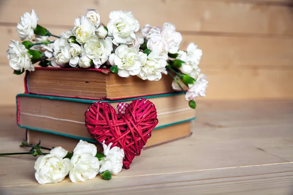 Gentle carnation in the old book on a wooden background. Valentine's Day — Stock Photo, Image
