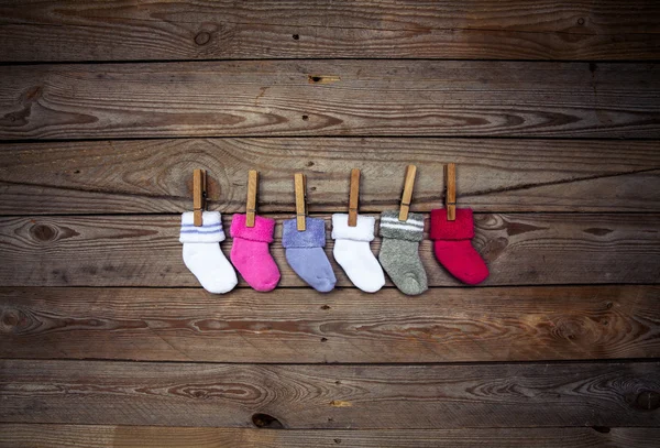 Knitted multicolored socks on a wooden background — Stock Photo, Image