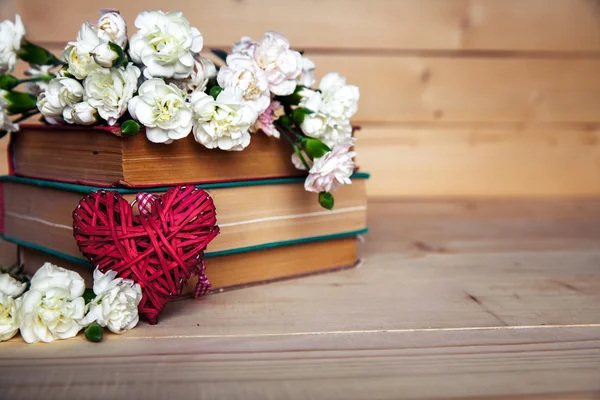 Gentle carnation in the old book on a wooden background. Valenti — Stock Photo, Image