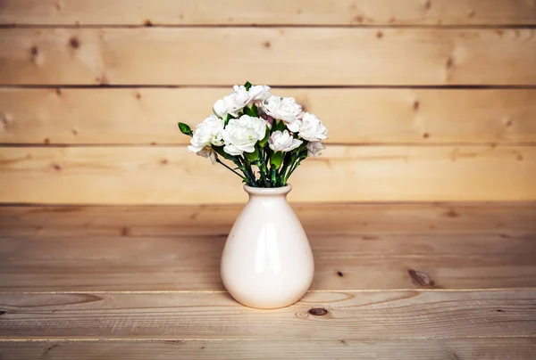 Delicate bouquet of carnations in vintage vase with heart on woo — Stock Photo, Image