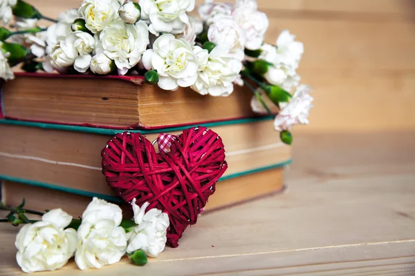Gentle carnation in the old book on a wooden background. Valentine's Day — Stock Photo, Image