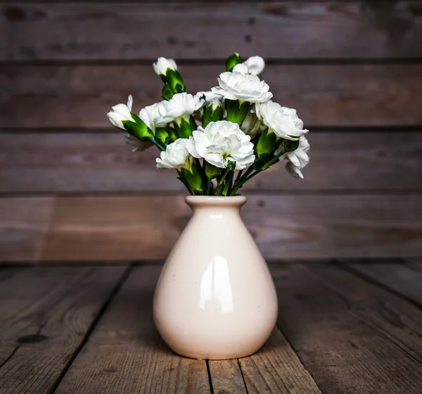 Delicado buquê de cravos em vaso vintage com coração em fundo de madeira. Dia dos Namorados — Fotografia de Stock
