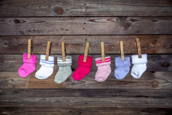 Šedé ponožky s clothespin na dřevěné pozadí — Stock fotografie