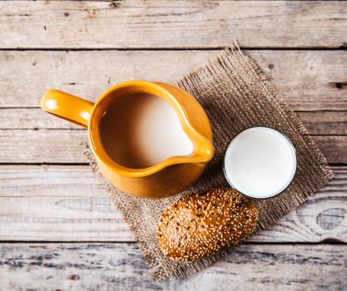 Sürahi süt ve bir rulo ahşap arka plan üzerinde. Gıda