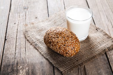 Bir bardak süt ve ahşap arka plan bir çörek. Gıda