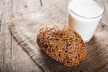 Bir bardak süt ve ahşap arka plan bir çörek. Gıda