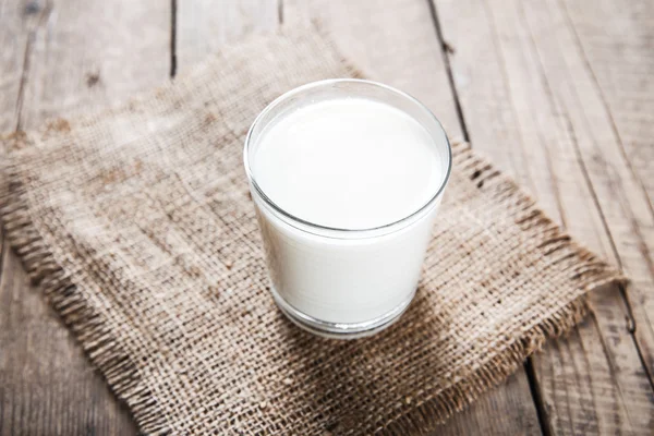 Glas Milch auf Holzgrund — Stockfoto