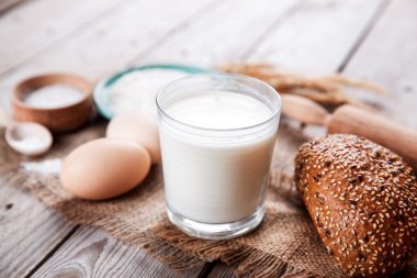 Malzemeler hamur işi ve bir bardak süt ahşap arka plan için. Gıda. pişirme