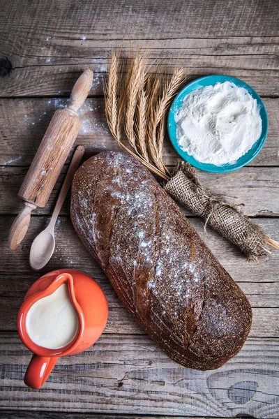 Food. composition of bread, spike, flour and milk on wooden background — Stock Photo, Image