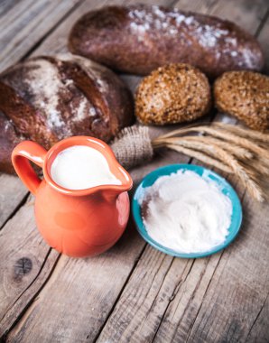 Gıda. ekmek, spike, un ve süt ahşap arka plan üzerinde kompozisyon