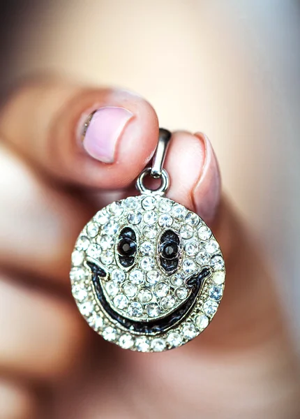 Pendant smile in female hands — Stock Photo, Image