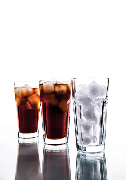 Tres vasos de cola y hielo sobre un fondo blanco. refrescos —  Fotos de Stock