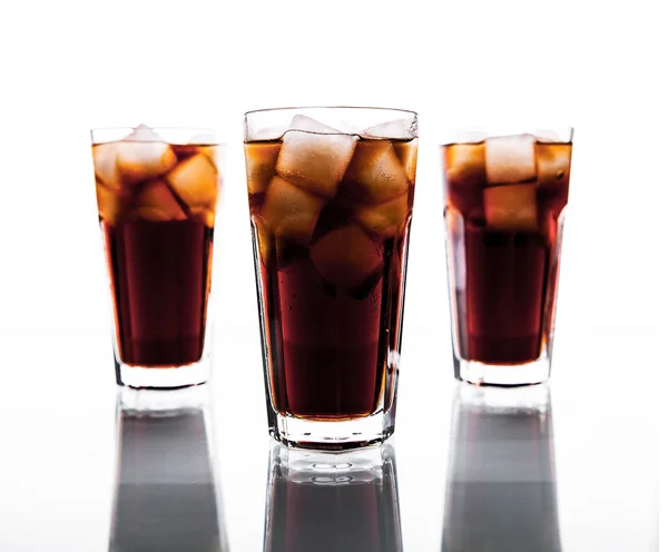 Tres vasos de cola y hielo sobre un fondo blanco. refrescos —  Fotos de Stock