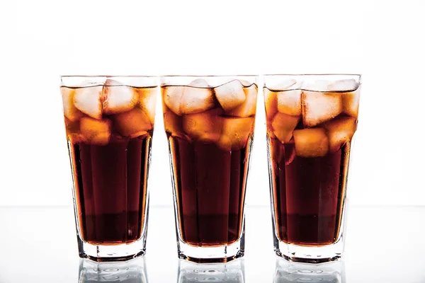 Tres vasos de cola y hielo sobre un fondo blanco. refrescos —  Fotos de Stock