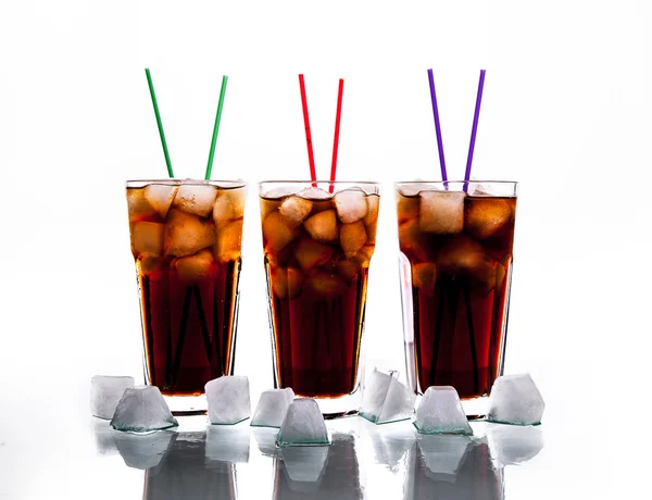 Tres vasos de cola con hielo y pajitas sobre un fondo blanco. refrescos —  Fotos de Stock