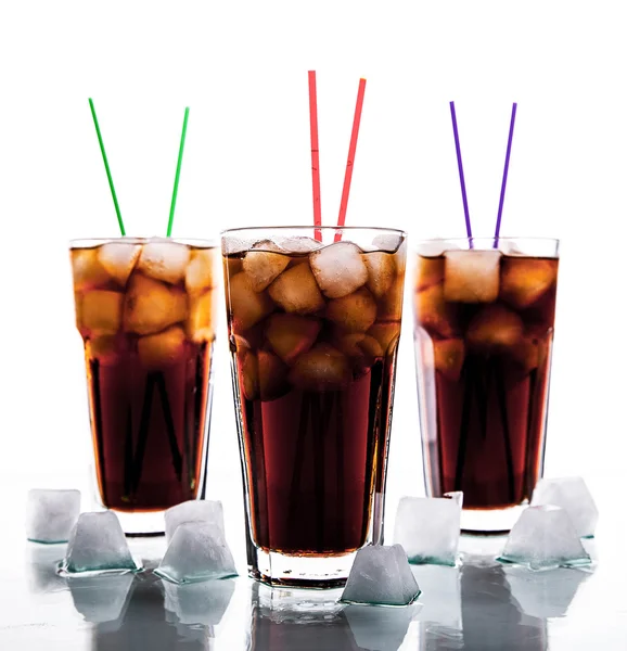 Tres vasos de cola con hielo y pajitas sobre fondo blanco . —  Fotos de Stock