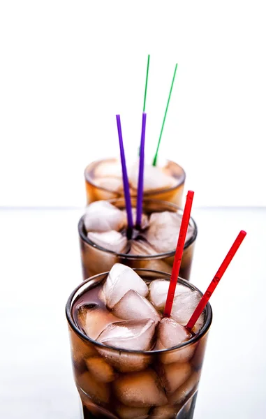 Three glasses of cola with ice and straws on a white background. — Stock Photo, Image