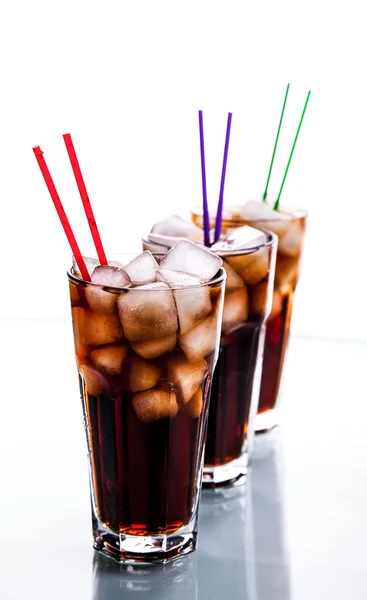 Trzy szklanki Cola z lodem i słomki na białym tle. — Zdjęcie stockowe