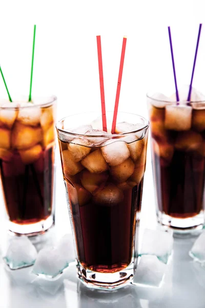 Tres vasos de cola con hielo y pajitas sobre fondo blanco . —  Fotos de Stock