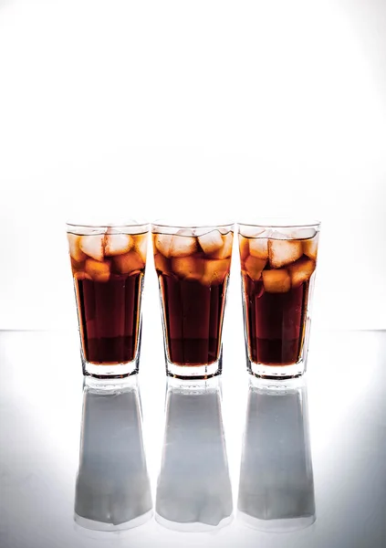Tiga gelas cola dan es di latar belakang putih. minuman ringan — Stok Foto