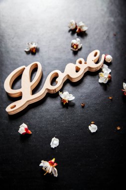 siyah bir arka plan ve ahşap bir işareti ile kelime aşk çiçek