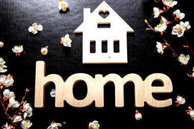 siyah bir arka plan ve kelime House ile ahşap bir işaret çiçek