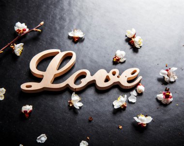 siyah bir arka plan ve ahşap bir işareti ile kelime aşk çiçek