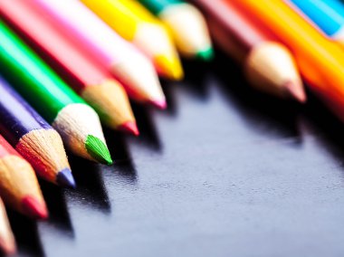 siyah arka plan üzerine izole renkli kalemler yakın çekim