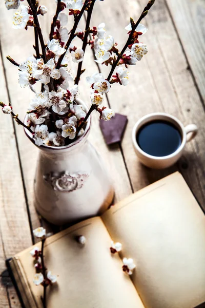 Peach blossoms in a vintage vase with a cup of coffee, chocolate — Stock Photo, Image