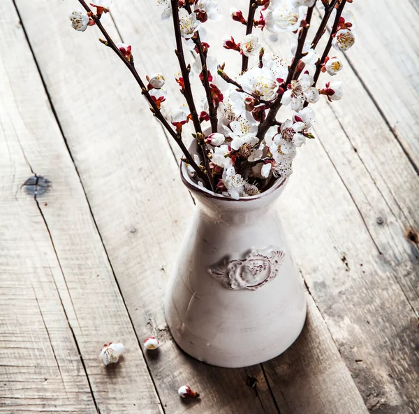 Spring blossoms in vintage vase on wooden surface — Stock Photo, Image