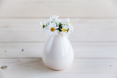 papatyalar bir ahşap zemin üzerine vazo