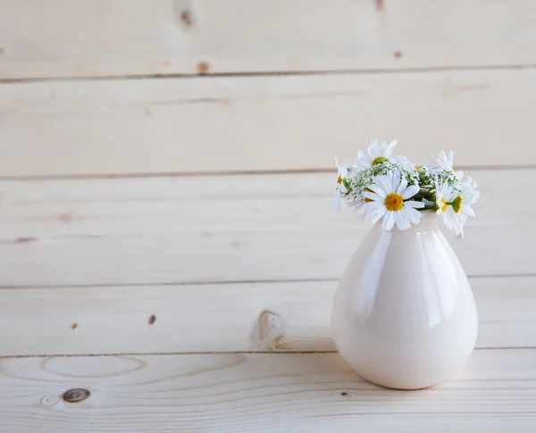 Vase of daisies on a wooden background — Stock Photo, Image