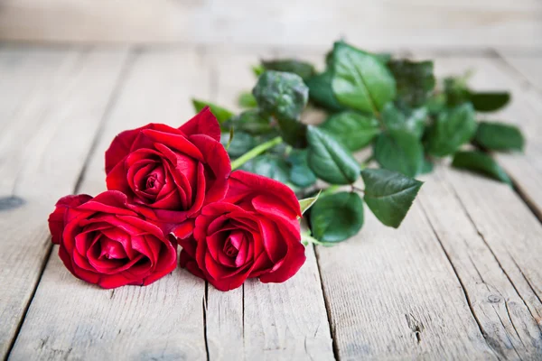 Rode rozen op houten ondergrond — Stockfoto