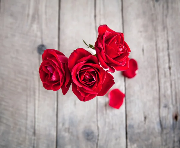 Rosa vermelha em vaso na mesa de madeira — Fotografia de Stock