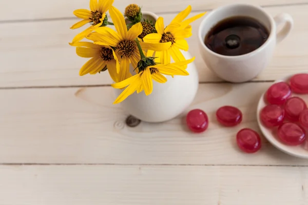 Ein schönes Arrangement aus gelben Blumen, Süßigkeiten und Kaffee — Stockfoto