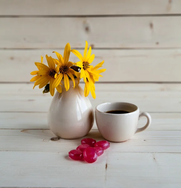 Una bella disposizione di fiori gialli, dolci e una tazza di caffè — Foto Stock