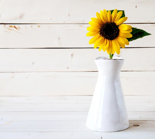 A bouquet of autumn sunflowers in a vase on a wooden table. — Stock Photo, Image