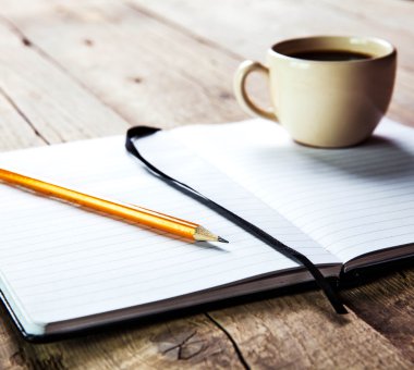 defter kalem ve ahşap masa kahve fincan