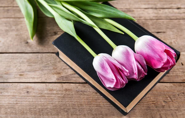 Des fleurs. tulipes roses sur un tas de vieux livres — Photo