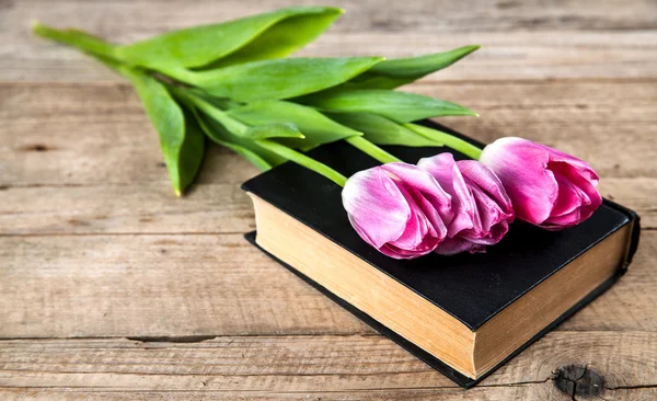 Flowers. pink tulips on a pile of old books — Stock Photo, Image