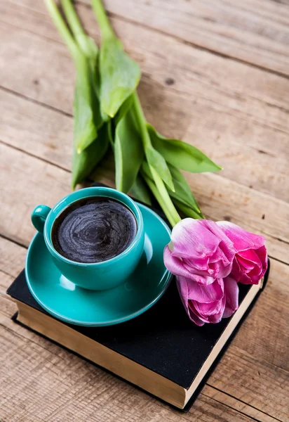 Kopje koffie op boek met bloemen. — Stockfoto