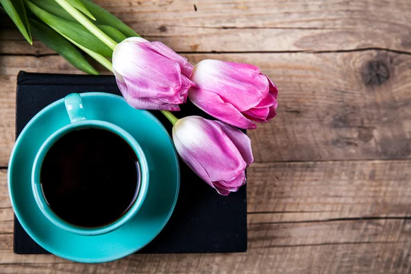 Kopje koffie op boek met bloemen. — Stockfoto
